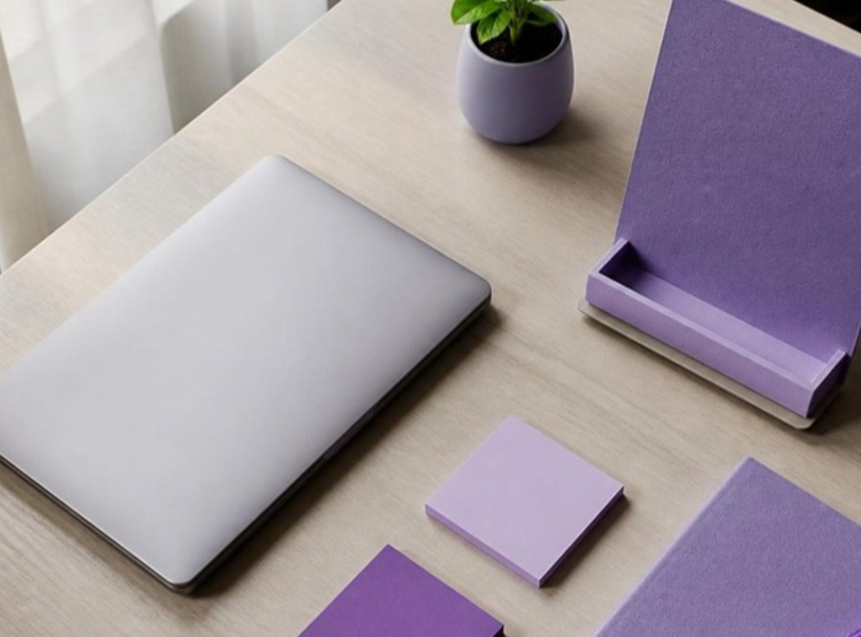 Marketing planning desk with laptop, display stand and sprout in lavender tones