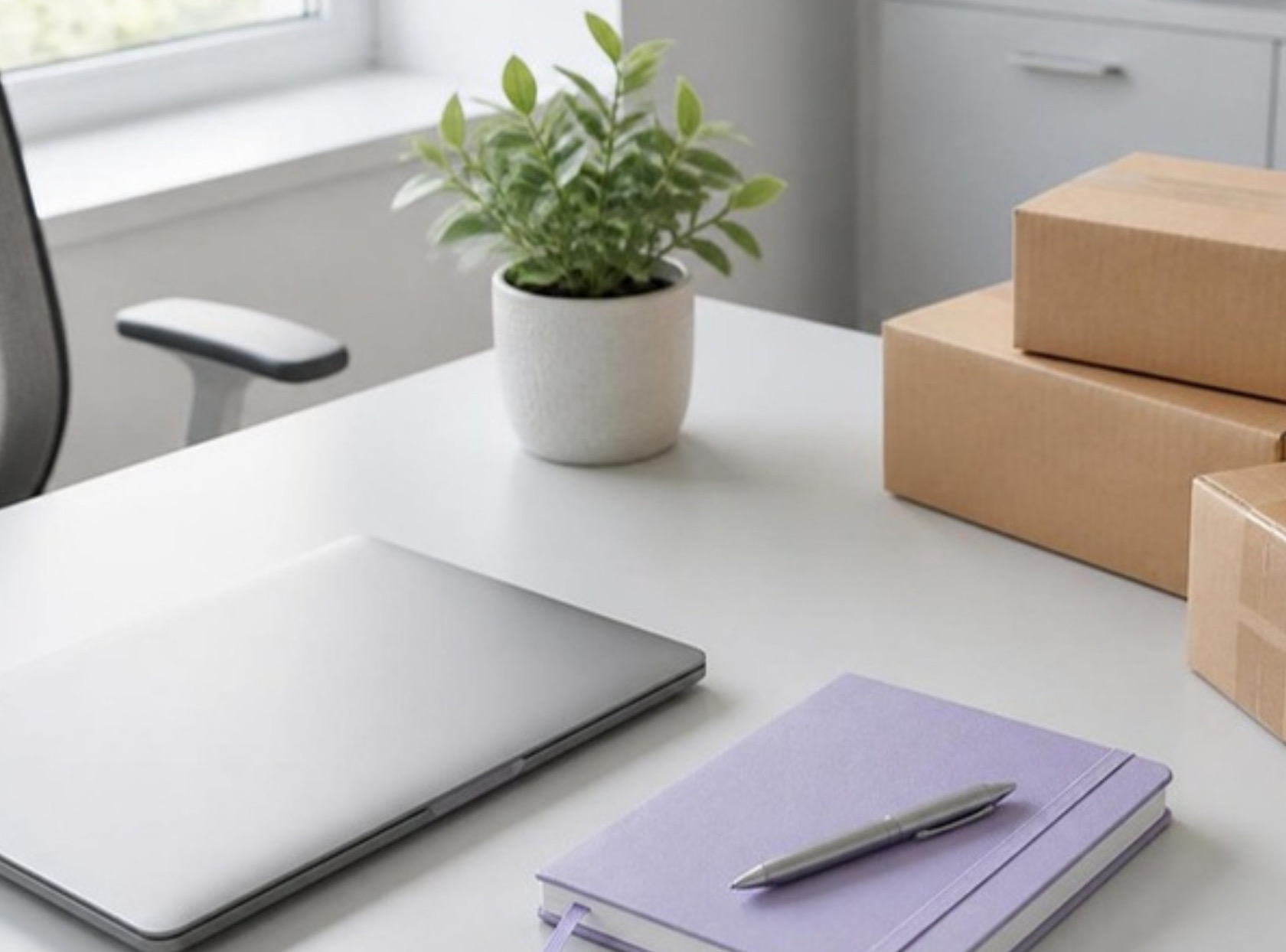 Tidy company desk with laptop, notebook and shipping parcels